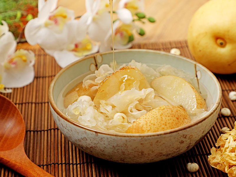 川贝银耳冰糖炖雪梨, poire cuite au sucre candi avec fritillaire et champignon blanc, dans un bol traditionnel sur un décor en bambou